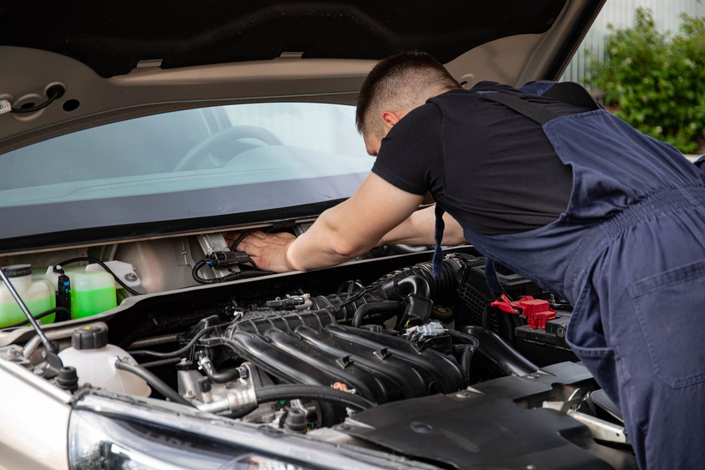 Mechanic working deep in a car engine bay